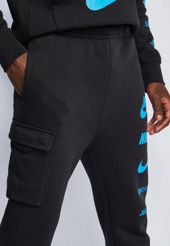 Nike Sportswear Standard Issue Hooded Tracksuit in Black Nike Men's Standard Issue Pullover Tracksuit set. - -. Soft and Warm comfortable Adjustable Drawcord Hood comes with Kangaroo Pouch Pocket, Logo Patch Pouch Pocket and multiple logos on the Sleeve, Elasticated Ribbed Cuffs & Hem Pullover Style hoodie. - -. Drawstring Closure Jogger, Elastic Cuffs and Drawcord Waistband for a Secure fit, the regular fit is Slim at the Hip and Relaxed through the Leg, 2 Side Pockets and Single cargo pocket design. - -. 80% Cotton, 20% Polyester. - -. Machine washable.