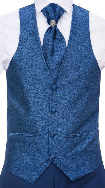 Sharp, sleek and sophisticated, look the part with this premium 4 piece Blue Suit, that features a Tailored Fit (inbetween Slim & Regular) with a closer fit across the chest and narrower tailored trousers. The jacket hangs beautifully and has a half canvas construction that moulds to your body shape the more you wear it. Contrasting flap pockets, buttoned cuffs and a single back vent lend the suit a classic touch of refinement. The suit features a Shawl Round Collar Design Blazer with a Unique Satin Paisley Contrast made from Soft Textured Fabric A paisley waistcoat completes the 4-piece with a 4-button down style with classic tailored pockets and a back adjuster to ensure you can create your ideal fit. The suit is evergreen and contemporary at the same time and allowing you to look the best all day. Pair it with a white shirt and shoes for a dapper finish.