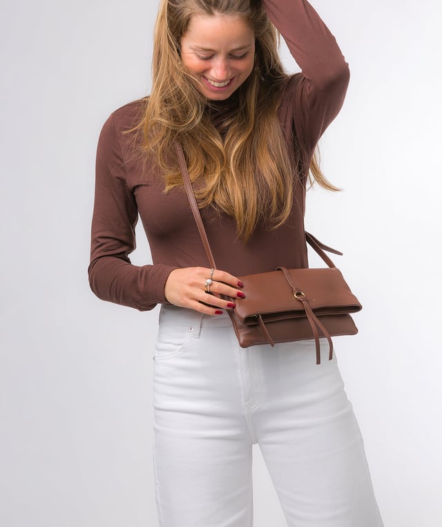 The 'Selene' cross body clutch bag from the Pure Luxuries Marylebone Collection is handcrafted from high-quality, genuine Nappa leather with a natural super-soft touch. The fold-over top secured by two magnetic press studs, opens to reveal a zipped main compartment and a slip pocket. The interior is lined with 100% cotton and includes two slip pockets to help maintain an organised bag. Comes with a matching and adjustable slim leather strap, with a maximum drop length of 65cm. The strap is also removable, transforming the bag into a clutch bag. Features gold-coloured metal fittings and zip. The Pure Luxuries logo is embossed for an effortless and sophisticated finishing touch.