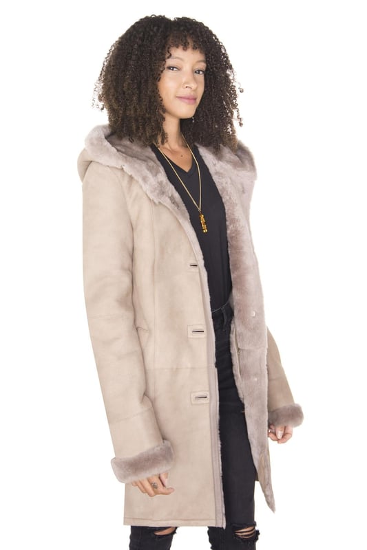 Las chaquetas de piel de oveja ganaron una enorme popularidad entre las celebridades en los años 1940 y 1950 y han sido consideradas como un símbolo de estatus para las mujeres durante varios períodos de tiempo. Nuestras chaquetas están confeccionadas con piel de oveja de doble cara de la más alta calidad y cuentan con un forro de lana grueso que es famoso por su capacidad natural para retener el calor corporal, lo que la convierte en la opción de material ideal durante el invierno. Esta chaqueta presenta un acabado de gamuza que se combina con un diseño minimalista para darle a esta chaqueta una elegante sensación de prestigio. La parte delantera de la chaqueta se mantiene tradicional con cuatro botones que sujetan la chaqueta hasta una capucha de piel de oveja, que cuenta con un forro grueso para mayor comodidad y para emitir un atractivo lujoso. Este abrigo aparece en combinaciones de colores premium beige y tostado, que son tonos cálidos que combinan bien con una variedad de colores y estilos. â€¢ Fabricado con piel de oveja de doble cara de alta calidad â€¢ El forro de piel de oveja grueso es famoso por brindar calidez y comodidad â€¢ Equipado con un cierre abotonado