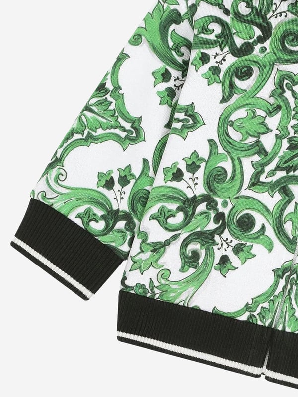 Dolce &amp; Gabbana utilise new technological properties to create captivating aesthetics. This baby boys zip up is a part of the FW24/25 Boy‚ôs Collection that boasts a ‚úcalligraphic-naturalistic‚ù Majolica accent. Crafted in a magnetic two-tone detailing ‚ì bright green and white- cotton jersey design with all-over green majolica print. Inspired by Sicilian tiles, it has ribbed trims and a black script logo on one side. He will be obsessed. ‚ Made in Italy‚ Zip Fastening‚ Machine Wash (30*C)‚ 100% Cotton (Soft Jersey)‚ Lining of Hood: 100% Jersey (Soft Jersey)