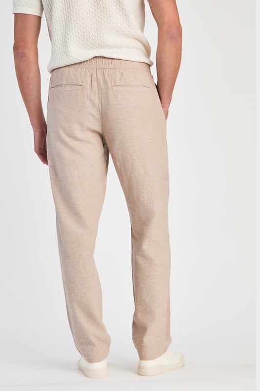 Beige Linen Blend Classic Fit Trousers Get stylish with these linen trousers from Nines by Kensington Eastside. Designed in a classic fit, these trousers feature an elasticated waistband and two side pockets. Made from a breathable blend of linen and cotton, these trousers are perfect for both casual and formal occasions. Machine washable for easy care, they are a versatile addition to any wardrobe.