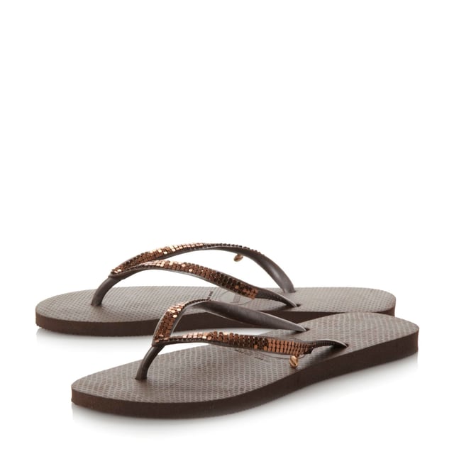 Add some sparkle to your summer style with this metallic mesh flip flop. A classic toe post style with slim straps and miniature branded coin charm.