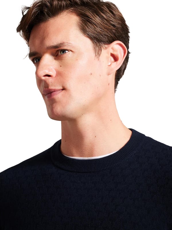 Ted Baker crew neck jumper är tillverkad av en premium ullblandning, med en rik, texturerad T-stickning som enkelt ger en touch av sofistikering till svalare dagar. De långa ärmarna ger värme, medan den klassiska runda halsringningen ger ett tidlöst utseende. Detta mångsidiga plagg är perfekt för en rad olika tillfällen