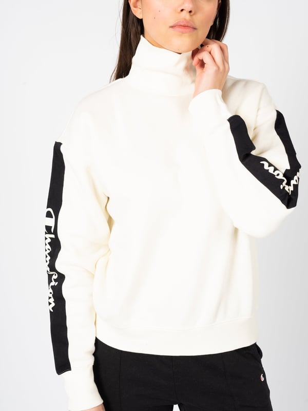 El corte sencillo de esta sudadera es sinónimo de elegancia clásica y versatilidad, haciéndola ideal para cualquier conjunto diario.

El cuello de tipo polo no solo es un elemento de moda, sino también práctico, proporcionando calidez y comodidad en los días más fríos.

Las mangas y el dobladillo terminados con puños garantizan un ajuste perfecto a la silueta y evitan que la tela se deslice indeseadamente.

A lo largo de las mangas, la cinta con el logo añade un toque deportivo y es un distintivo sutil pero reconocible de la marca.

Hecha con tejido de alta calidad, la sudadera garantiza durabilidad y comodidad al usarla, convirtiéndose en una pieza imprescindible en el guardarropa durante muchas temporadas.