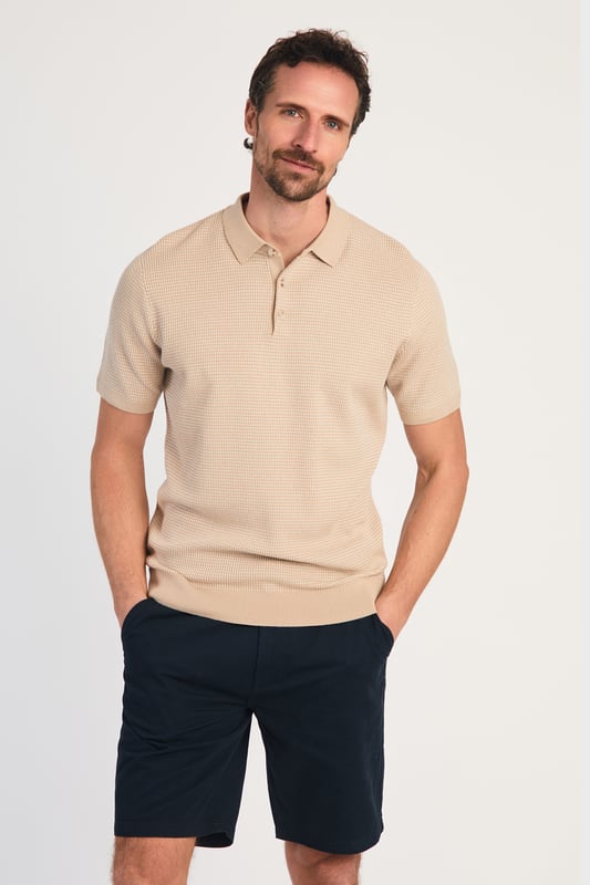 This textured polo shirt from Kensington Eastside blends classic sophistication with modern design. Crafted from a premium knit fabric with a subtle pattern, it offers a refined yet contemporary look. Lightweight and breathable, it’s a versatile choice for smart-casual occasions, ensuring style and comfort effortlessly. Made from 100% Cotton.