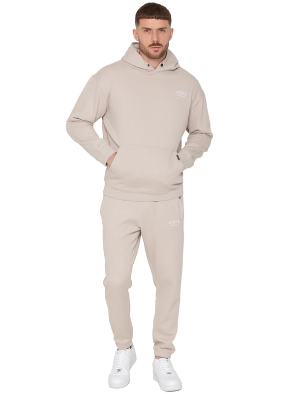 Presentamos el Conjunto de Chándal con Sudadera con Capucha Oversized Averè para Hombre de Enzo Milano, una mezcla perfecta de comodidad y estilo. Este set incluye una Sudadera con Capucha Oversized con un suave forro de felpa, un logotipo sutil en el pecho, un diseño audaz en la parte trasera y una capucha con botones a presión. Los Joggers de Corte Regular tienen una cintura elástica, cordones ajustables, bolsillos laterales y puños acanalados en los tobillos para un ajuste seguro. Ideal para relajarse o para salidas casuales, este chándal ofrece un estilo relajado y a la moda