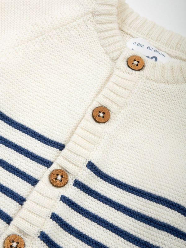 100% organic cotton | Proud to be certified to the Global Organic Textile Standard (GOTS) | Cream with navy blue stripes | Midweight 7-gauge transfer knit | Coconut button fastening | Long sleeved | Round neck | Ribbed cuffs and hem | Made in India | Machine washable at 40 degrees, or at 30 degrees to be kinder to the planet