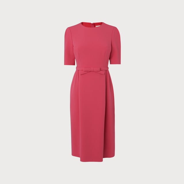 The perfect pink shift, our Elina dress takes its cues from bespoke occasion dresses of an era gone by. Crafted from raspberry pink crepe, it has a round neck, short sleeves, a neat bow belt at the waist and a front panel to the knee-length skirt. Simple and chic, wear it with strappy heels or sleek courts for during the occasion season.