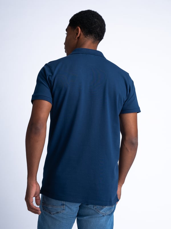 Unifarbenes Poloshirt mit offenem Kragen und Knopfleiste. Das Poloshirt ist mit einem im Brustbereich applizierten Petrol-Badge ausgeführt. In verschiedenen Farben erhältlich. Du schwankst zwischen zwei Größen? Nimm die größere Größe! Kurzarm-PoloshirtUnifarbenOffener KragenKnopfverschlussPetrol-Logo95 % Baumwolle, 5 % Elasthan