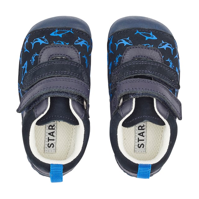 A fin-tastic casual style pre-walker, specifically designed for tiny toes and chubby feet. Little Fin is crafted from a soft navy nubuck with an adorable shark print. Heel and toe bumpers protect little feet and ultra-flexible lightweight soles give unrestricted movement and barefoot comfort. There's a double rip-tape fastening for a snug fit and easy adjustment.
