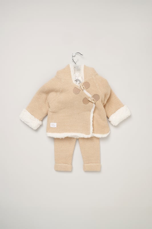 Wrap your little one in cosy comfort with Rock A Bye Baby Boutique's true knit cardigan set. The set features a cardigan with toggle fastening, an inside sherpa lining and a matching pair of knitted trousers. Perfect for outings, it ensures your baby stays snug and adorable.