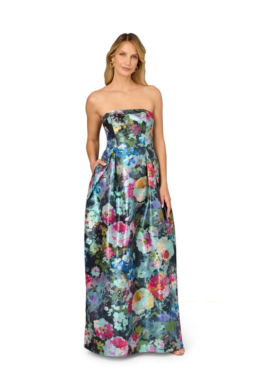 Luxurious details elevate this metallic floral ball gown. This evening gown features a fitted bodice with boning for structure, a strapless straight neckline with fold over detail, and a full ball skirt. Designed from floral print metallic jacquard fabric imported from France, this ball gown has crinoline under the pleated skirt for added volume. A hidden zipper closure at the centre back and pockets within the skirt completes this strapless gown. A perfect look for a black-tie event or formal wedding, this floral gown looks great when paired with nude heels and a statement-making clutch.