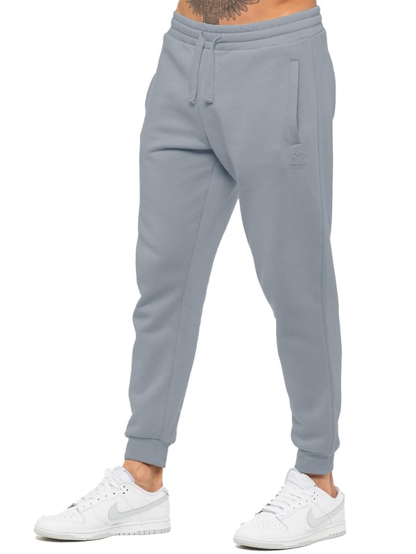 Experience ultimate comfort in our Enzo Mens Regular Fit Joggers. Made with a soft brushed back inner fleece lining, these joggers are perfect for casual wear. The cuffed leg design and elasticated waist with drawstrings provide the perfect fit. With 2 side slash pockets, you can easily carry your essentials.