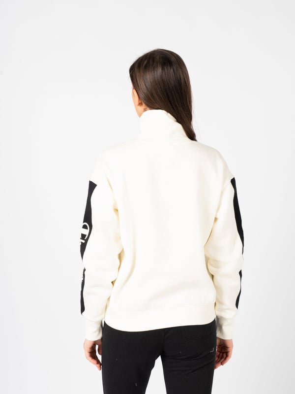 El corte sencillo de esta sudadera es sinónimo de elegancia clásica y versatilidad, haciéndola ideal para cualquier conjunto diario.

El cuello de tipo polo no solo es un elemento de moda, sino también práctico, proporcionando calidez y comodidad en los días más fríos.

Las mangas y el dobladillo terminados con puños garantizan un ajuste perfecto a la silueta y evitan que la tela se deslice indeseadamente.

A lo largo de las mangas, la cinta con el logo añade un toque deportivo y es un distintivo sutil pero reconocible de la marca.

Hecha con tejido de alta calidad, la sudadera garantiza durabilidad y comodidad al usarla, convirtiéndose en una pieza imprescindible en el guardarropa durante muchas temporadas.