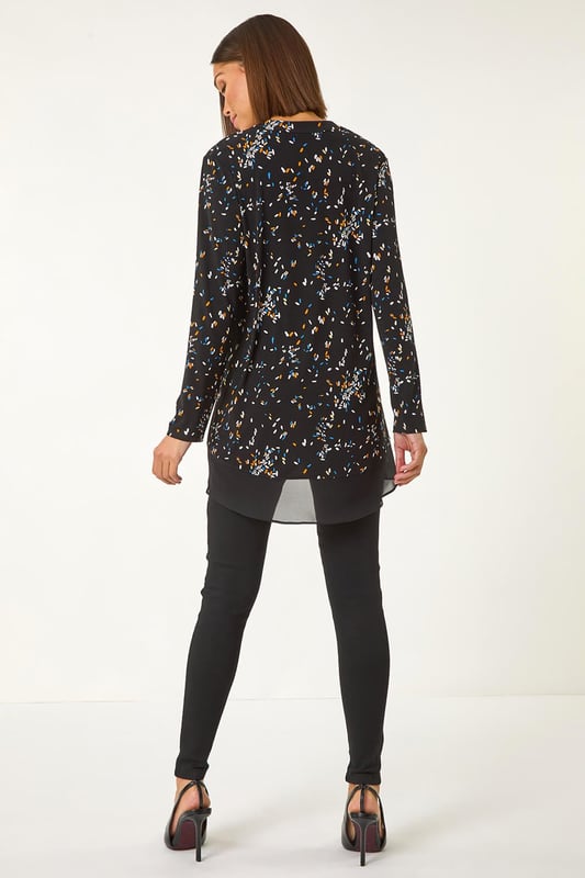 Abstract Print V-Neck Tunic Top from Roman. Inject some fun into your wardrobe with this abstract print tunic top, perfect for the Autumn Winter season. The flattering v-neckline and long sleeves will keep you warm and stylish. Crafted from stretchy jersey fabric, this top features a vibrant abstract print with a contrasting hem, all designed in a trendy tunic shape. Simply pair with jeggings and ankle boots for a fashionable fall look.