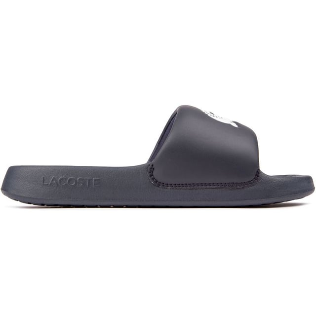 Lacoste Serve Slide Sandalias Saluda a este elegante y cómodo par de chanclas de estilo de vida, las Serve Slides de Lacoste. Perfectas para tus días en la piscina, visitas al spa o simplemente como un básico diario de verano, estas sandalias te tienen cubierto. Ponte las elegantes sandalias azules y siente la comodidad de una correa superior acolchada suave y flexible y una plantilla moldeada y acolchada que abraza tus pies. El diseño elegante y minimalista presenta la famosa marca llamativa en la correa ancha. Muestra tu estilo relajado y tus looks de clima cálido.