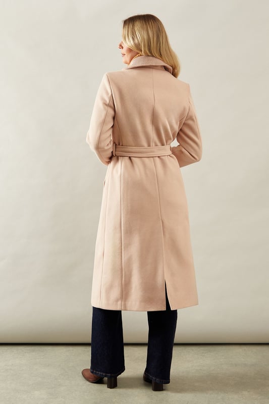 Elegant knitted collar for added sophistication
        Wrap design with button-through closure for versatile styling
        Long length offers maximum coverage and warmth
        Belted waist creates a flattering silhouette
        Functional side pockets for practicality
    
    This Wallis Knitted Collar Button Through Wrap Coat is the epitome of refined elegance. Perfect for the woman who appreciates sophistication without compromising on comfort, this coat is a versatile addition to any wardrobe. The wrap design allows for customisable fit, while the button-through closure adds a touch of classic charm. Style it over a sleek midi dress and pair with heeled boots for a polished look at formal events. For smart casual occasions, layer it over tailored trousers and a fine knit jumper, completing the ensemble with leather ankle boots. The long length and belted waist not only provide warmth but also create a striking silhouette that's sure to turn heads. Whether you're attending a business meeting or heading to a sophisticated dinner, this coat will ensure you look impeccably put-together while feeling effortlessly comfortable.