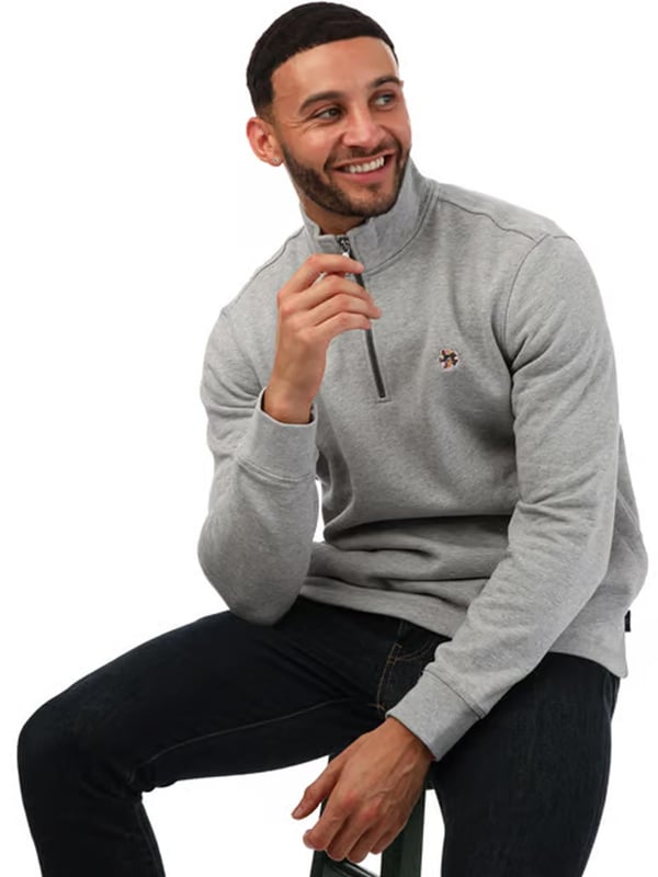 Upgrade je casual garderobe met de Ted Baker Kilburn Half Zip Sweatshirt voor heren in grijs. Met een stijlvolle hoge hals en halve rits voor gemakkelijke draagbaarheid biedt deze trui zowel comfort als een strakke uitstraling. Voorzien van geribbelde boorden en zoom voor een perfecte pasvorm, terwijl het kenmerkende Magnolia-accent een verfijnde touch geeft. Gemaakt van 100% katoen, is dit regular-fit kledingstuk perfect voor dagelijks comfort en stijl