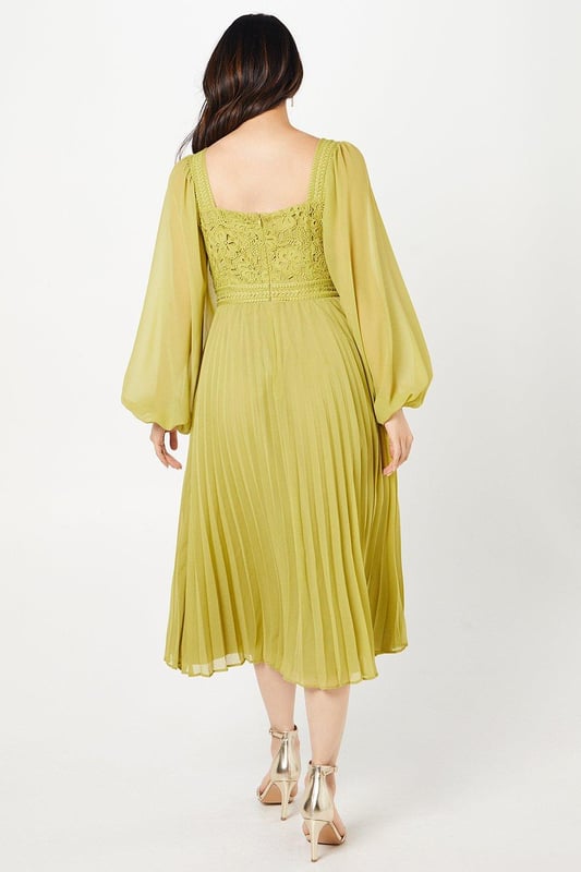 Exquisite lace bodice with intricate floral detailing
        Elegant square neckline for a sophisticated look
        Voluminous bishop sleeves add drama and flair
        Pleated chiffon skirt creates graceful movement
        Midi length perfect for formal occasions
    
    This stunning Coast dress combines timeless elegance with contemporary flair, making it an ideal choice for weddings, races, or any sophisticated soire. The lace bodice, adorned with delicate floral patterns, creates a captivating focal point, while the square neckline frames the dcolletage beautifully. The billowing bishop sleeves add a touch of romance and drama to the silhouette. The pleated chiffon skirt flows gracefully from the waist, offering both comfort and style as you move. To complete your ensemble, pair this dress with strappy metallic heels and delicate drop earrings. For a polished daytime look, layer with a tailored blazer and accessorise with a fascinator for the races. This versatile piece effortlessly transitions from day to evening events, ensuring you'll be the epitome of sophistication at any occasion.