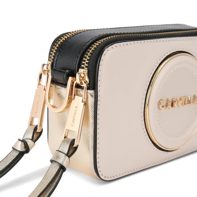 This Carvela Mini Roma Circle cross body bag features a bone exterior with round embossed branding on the front. There is branded gold hardware across the bag. Dimensions: 11cm (H), 18cm (L), 5cm (D). Strap length: 126cm.