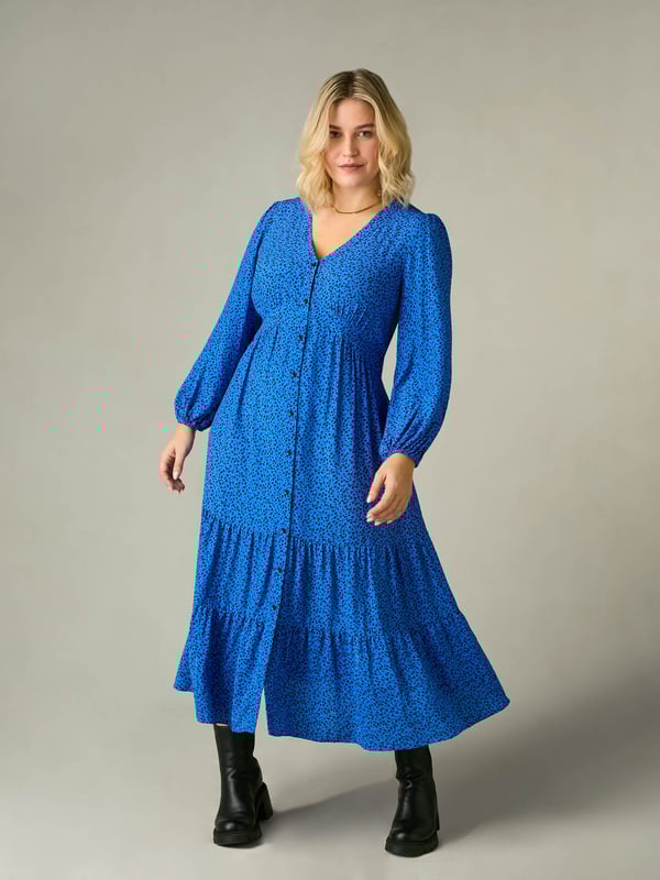 Printed all over with a beautiful blue ditsy print, this dress is cut from a soft woven fabric that moves beautifully. With a flattering tiered shape, it has a button-through front and an elasticated waistband to ensure the perfect fit. Voluminous sleeves add to its elegant silhouette, making it the perfect dress to elevate your everyday.