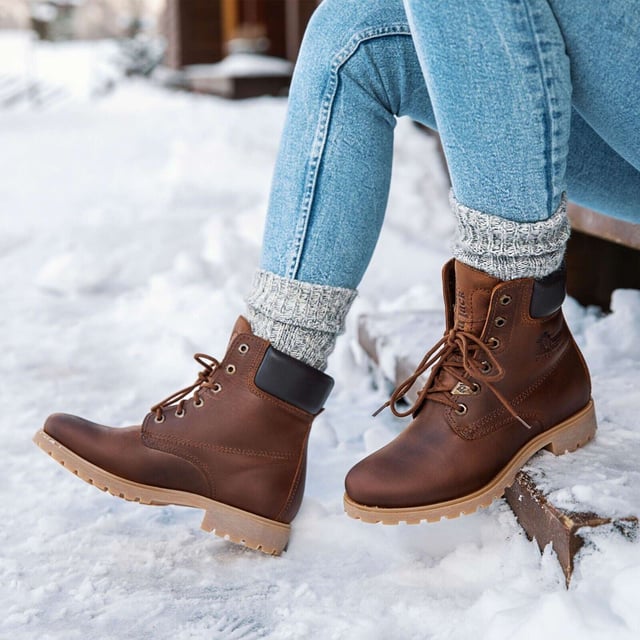 Steigen Sie mit Stil und Komfort aus mit Panama Jack-Stiefeln. Egal, ob Sie über schroffe Landwege wandern oder durch städtische Straßen navigieren, der originale Panama Jack 03 B168 Damen-Schnürstiefel ist Ihr perfekter Begleiter. Diese Stiefel zeichnen sich durch ein klassisches Design mit einer schlichten runden Spitze und einem dunkelbraunen, gepolsterten Lederkragen aus und strahlen zeitlose Eleganz aus. Die genähte Commando-Sohle sorgt für Haltbarkeit und Stabilität auf jedem Gelände. Die braunen Panama Jack 03 Schnürstiefeletten für Damen sind so konzipiert, dass sie den Elementen standhalten. Mit einem wasserdichten, glatten Nubuk-Obermaterial, einem weich gepolsterten Knöchelschaft und einem warmen Futter halten diese Stiefel Ihre Füße kuschelig und trocken. Das geprägte Logo an der Ferse und die silbernen sechseckigen Metallösen verleihen ihrem robusten Charme einen Hauch von Raffinesse. Hauptmerkmale: Klassisches Design: Die Panama 03-Stiefel vereinen Design, Qualität und Komfort nahtlos und bieten eine zeitlose Ästhetik für Männer und Frauen. Vielseitiger Tragekomfort: Egal, ob Sie die Straßen der Stadt erkunden oder Bergpfade erobern, diese Stiefel sind perfekt für alle Ihre täglichen Abenteuer. Wasserdichte Konstruktion: Diese Stiefel sind aus wasserdichtem Vintage-Nappaleder mit Lederfutter gefertigt und sorgen dafür, dass Ihre Füße bei jedem Wetter trocken und bequem bleiben. Anatomische Unterstützung: Genießen Sie verbesserten Komfort und Hygiene mit der anatomisch geformten Innensohle, die eine perfekte Passform für Ihre Füße bietet. Langlebig und rutschfest: Die Gummiaußensohle bietet Flexibilität, Haltbarkeit und rutschfeste Traktion und sorgt für Stabilität auf verschiedenen Oberflächen. Hergestellt in Spanien: Mit einer Schafthöhe von 18 cm werden diese Stiefel fachmännisch in Spanien gefertigt, um höchste Handwerkskunst und Qualität zu gewährleisten. Schlüpfen Sie in die Stiefel von Panama Jack und erleben Sie die perfekte Mischung aus Stil, Haltbarkeit und Komfort für Ihre alltäglichen Abenteuer. Diese Stiefel wurden für alle entwickelt, die Wert auf Qualität und Handwerkskunst legen und sind Ihr vertrauenswürdiger Begleiter, wohin auch immer Ihre Reise Sie führt