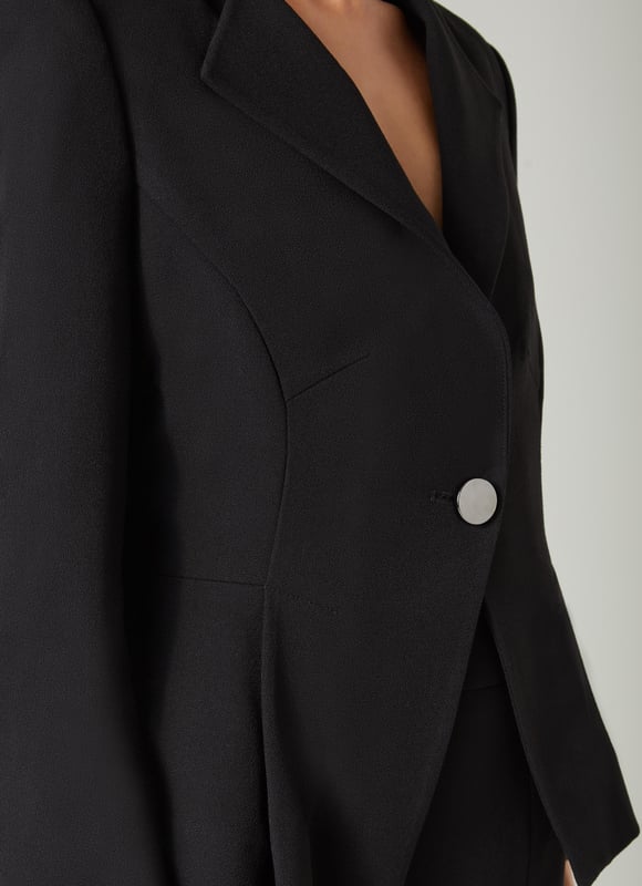 Beautifully tailored, totally timeless and kind to our planet, the new Sky jacket works as part of a wear-forever suit with the Sky skirt. Crafted in Europe from a black LENZING™ ECOVERO™ viscose* blend crepe, it's a shapely, single-button style with an open collar, a cut-away front and bracelet sleeves with button detail. Wear it with the matching pencil skirt when occasions call or for days in the office. This suit is a keeper. 

*More about the fabric
LENZING™ ECOVERO™ viscose uses up to 50% less emissions and 50% less water than standard viscose. This fibre relies on wood pulp, and is crafted from sustaibly maged tree species such as beech, spruce and eucalyptus.