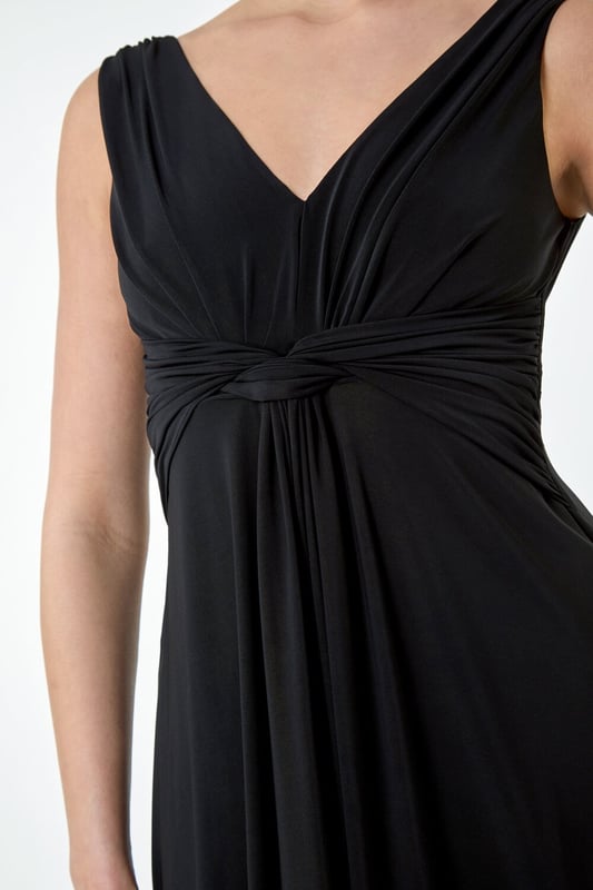 Plain Knot Front Maxi Dress from Roman. Turn heads in this luxuriously elegant knot front maxi dress. This exquisite sleeveless dress features a flattering v-neckline and a striking v-back detail, ensuring you make a sophisticated statement. With a fit and flare silhouette, this plain dress is fitted at the waist and flows into a floor-sweeping length, perfect for special occasions. The stretch jersey fabric drapes beautifully, while the knot detail at the waist adds an extra touch of glamour. Whether you're attending a wedding reception or a formal dinner, pair with strappy heels and a fascinator for a Summer wedding look.
