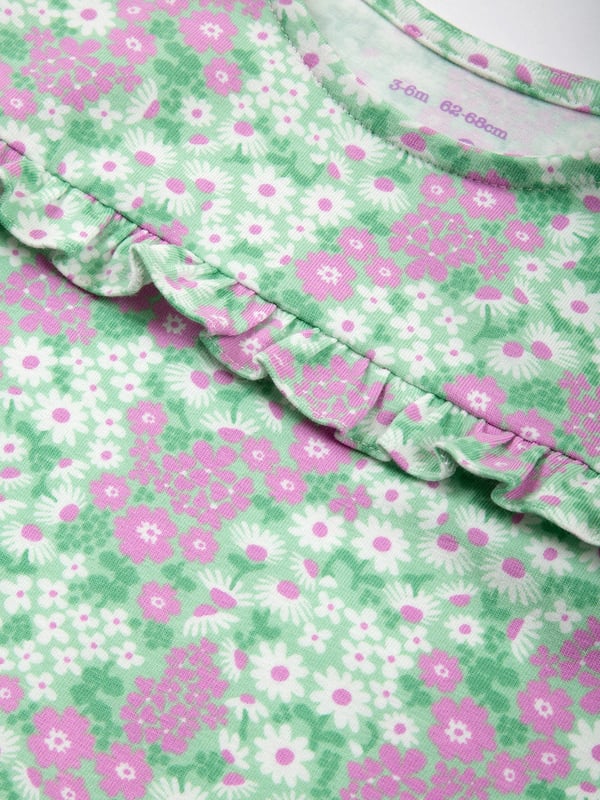95% organic cotton 5% elastane | Proud to be certified to the Global Organic Textile Standard (GOTS) | Flower patch all-over print | Slub jersey with a little stretch (170-180 gsm) | Coconut button shoulder opening | Popper crotch opening | Short sleeved | Short legs | Frill detail at yoke | Made in Turkey | Machine washable at 40 degrees, or at 30 degrees to be kinder to the planet