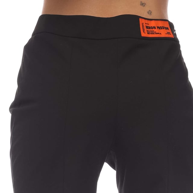 Womens Heron Preston Garbardine Stretch Zip Pants in black.- Elasticated waistband.- Pockets at side.- Orange logo patch sewn at waist on the back.- Zip fastening at front legs.- Stretch.- 66% Polyester  28% Viscose  6% Elastane.- Ref: HWCA028S211000