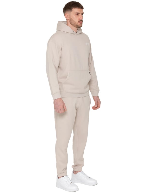 Presentamos el Conjunto de Chándal con Sudadera con Capucha Oversized Averè para Hombre de Enzo Milano, una mezcla perfecta de comodidad y estilo. Este set incluye una Sudadera con Capucha Oversized con un suave forro de felpa, un logotipo sutil en el pecho, un diseño audaz en la parte trasera y una capucha con botones a presión. Los Joggers de Corte Regular tienen una cintura elástica, cordones ajustables, bolsillos laterales y puños acanalados en los tobillos para un ajuste seguro. Ideal para relajarse o para salidas casuales, este chándal ofrece un estilo relajado y a la moda