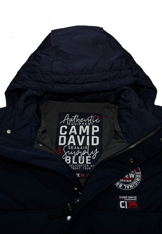 Diese Steppjacke für Herren ist ideal für kältere Tage. Es hat eine reguläre Passform, die genügend Bewegungsfreiheit und hohen Tragekomfort bietet. Die Jacke verfügt über einen hohen Stehkragen und eine zusätzliche, separat mit Druckknöpfen verschließbare Kapuze – der optimale Schutz vor Wind und Kälte. Die Jacke selbst wird mit einem verdeckten Reißverschluss geschlossen. In den beiden Seitentaschen können Essentials verstaut werden. Diverse Label-Details runden das Design ab.
