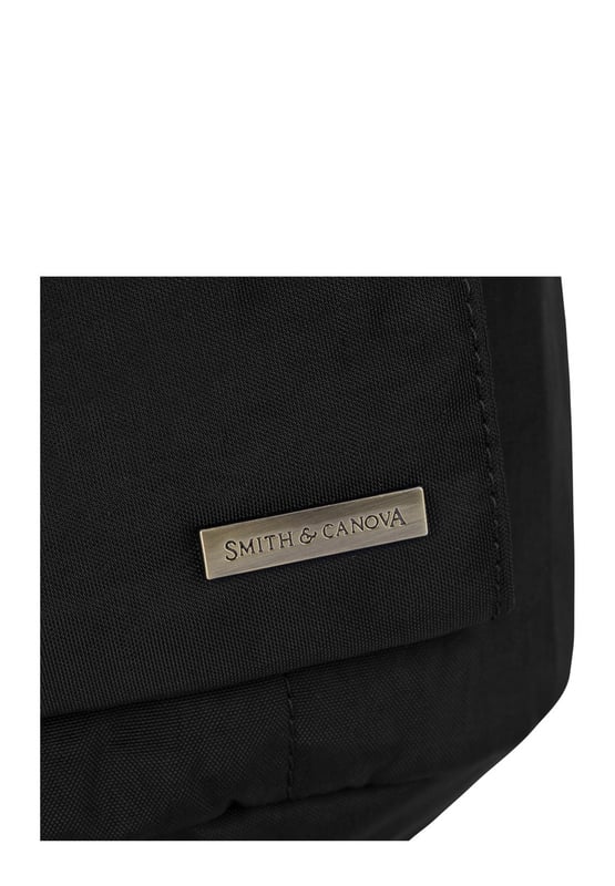 The Zip Around Nylon Backpack is the go-to bag for everyday essentials. The classic silhouette is cut in our signature nylon featuring a flap over zip pocket to the front. Inside features a 15” padded laptop sleeve with additional internal pockets for organised storage. Features: , Zip top opening, Front flap over zip pocket, Rear zip pocket, SMITH & CANOVA antique brass logo, Branded antique brass zips, Padded grab handle, Adjustable padded backpack straps, Internal 15 inch padded laptop sleeve, Internal zip pocket, 2 Internal mobile phone slip pockets - fits normal and plus size smart phones, 2 Internal pen slip pockets Style Ref: 92681 BLACK