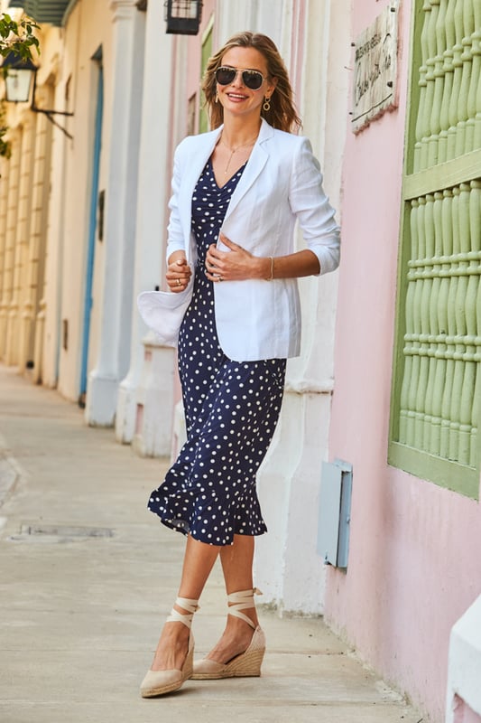 REASONS TO BUY:

The dress that feels as good as it looks
Super-comfy fabric
Chic navy polka dot print
Flattering V-neck and waist tie
Feminine ruffle hem
We're wearing it with a white blazer and wedges