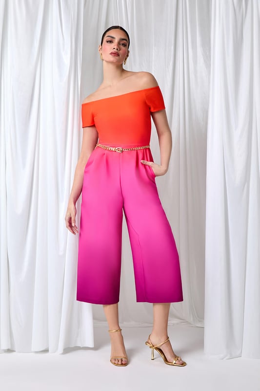 A-Ombre Bardot JSuit from Roman. Elevate your occasionwear this Summer with a vibrant ombre print jumpsuit! The perfect alternative to an occasion dress, this jumpsuit is cut in a flattering wide leg shape with culotte trousers and handy side pockets. Cinched in with a detachable metal belt, this ombre style has a striking gradient design and an even more flattering bardot neckline. Finishing off the shoulder with short sleeves, this stretch style has pleat details at the waist to create a feminine flow. Style yours with strappy heels for your next Summer event!