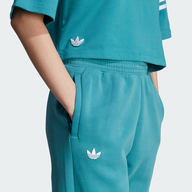 Stay sharp even when the day calls for relaxation. These adidas Adicolor joggers blend a sporty vibe with stylish design to make sure you look good even in your downtime. 3-Stripes around one leg add an unexpected, asymmetrical look to the casual, laid-back piece. Whether you're chilling at home or need to step out of the house, these relaxed-fit pants make sure you always look on point.A minimum of 70% of this product is a blend of recycled and renewable materials.  - This model is 175 cm and wears a size S. Their chest measures 81 cm and the waist 60 cm. - Relaxed fit - Drawcord on elastic waist - 66% cotton, 34% polyester (recycled) - Side zip pockets - Elastic cuffs  Shipped by adidas