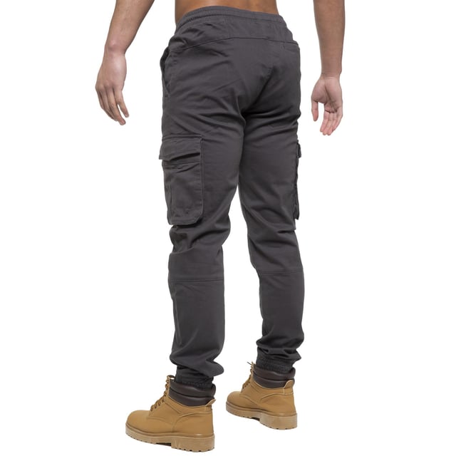 Enzo Mens Elasticated Waist Stretch Cuffed Jeans. Features a 5 Pocket Design. 2 Slash Pockets, 1 Back Pocket 2 Front Cargo, Bellow Side Pockets With Velcro Fastening. Elasticated Waist With Adjustable Drawstings. Cut and Sew Design On Leg. Cuffed Ankle