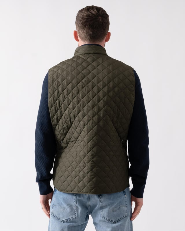The Icon Gilet in gunmetal. A diamond-quilted padded vest that can be snapped into the Trialmaster and Fieldmaster jackets to add a warming mid-layer.

Quilted recycled nylon
Snaps into the Trialmaster, Trialmaster Panther Jacket and Fieldmaster Jacket
Soft corduroy collar
Belstaff phoenix patch
Press-stud collar fastening
Snap-fastening waist adjustors
Two large lower press-stud pockets
Recycled polyester

Shell: 100% polyester, Lining: 100% polyester, Filling: 100% polyester
105295