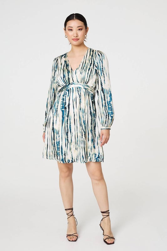 All body types look great in an empire waist dress. This one has a short length hem with long puff sleeves and a v-neck. The relaxed fit means you'll look effortlessly put-together at your next dinner, party or event.