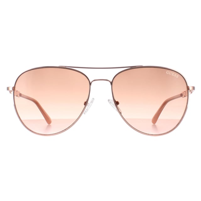 Guess Aviator Womens Shiny Rose Gold Brown Gradient GF6143  Sunglasses are a glamorous aviator frame, exuding a sense of timeless elegance. The frame is crafted from high-quality metal, known for its durability and lightweight feel, ensuring long-lasting comfort throughout the day. The slender temples feature the Guess logo for authenticity.
