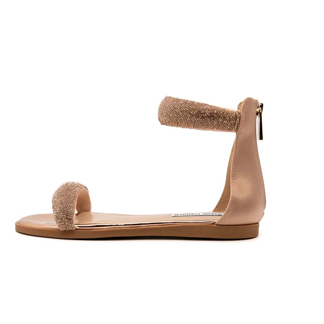 Kleur: Rose Gold Specificaties: Platte sandalen met gewatteerde voorkant en enkelband bedekt met strass steentjes. Achterrits gesloten hiel. Comfortabel en veelzijdig, zonder aan elegantie in te boeten. Bovenwerk: synthetisch materiaal Vetersluiting: ritssluiting Zooltype: antislip rubberen zool