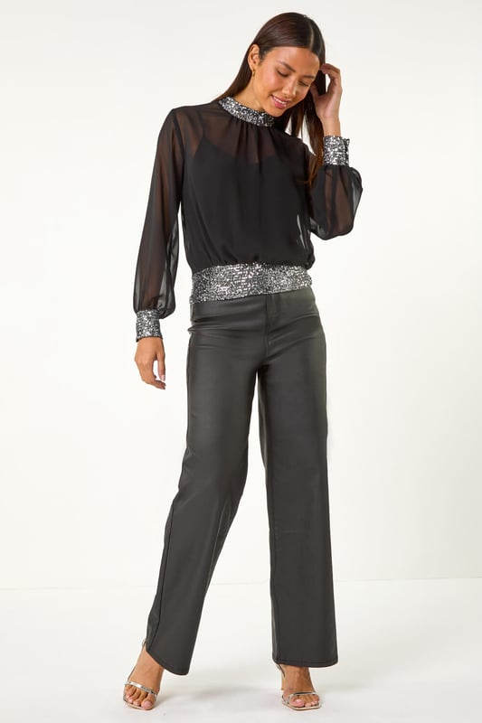 Sequin Detail Top from Roman. Shine bright in this glamourous sequin detail top, perfect for the Autumn/Winter season. Crafted from a delicate chiffon fabric, this top features intricate sequin detailing on the neck, cuffs, and hem for a touch of sparkle. The high neck and long sleeves add an elegant touch, while the included jersey cami provides coverage. Pair with tights and a skirt for a chic and festive look that will turn heads wherever you go!