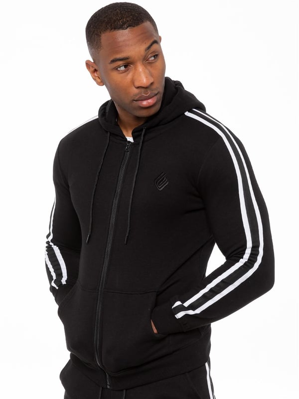 Enzo Mens Tape Hoodie Full Zip Tracksuit. Zip Through Hooded Top. Enzo Embroidery Logo on Chest and Contrast Stripe Design on Sleeves. Hoodie with Drawstring. Ribbed Waist and Cuffs. Kangaroo Pockets. Enzo Mens Casual Designer Striped Tracksuit Joggers. Featuring Classic Contrast Stripes to Sides. 2 Side Pockets. Cotton Blend for Superior Comfort. Adjustable Waist with Drawstrings. Athleisure Perfect for All Gym wear