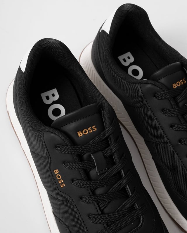 Las zapatillas de running Titanium Runn de BOSS son unas zapatillas clásicas con un toque urbano. Están confeccionadas con materiales de calidad y diseñadas para destacarse, con una parte superior negra elegante, un logotipo dorado en relieve, una plantilla acolchada y una suela exterior y una almohadilla para el talón de estilo running en color blanco. Estas zapatillas de diseño te mantendrán a la vanguardia de la carrera.