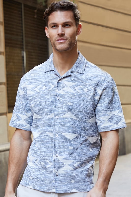 Freshen up your wardrobe with this bold tribal print shirt from Threadbare. This short sleeve shirt is an essential for bringing a bit of style to your outfit and is finished with a revere collar and button down fastening.
Team in the daytime with denim shorts or smarten up with a pair of chino shorts.