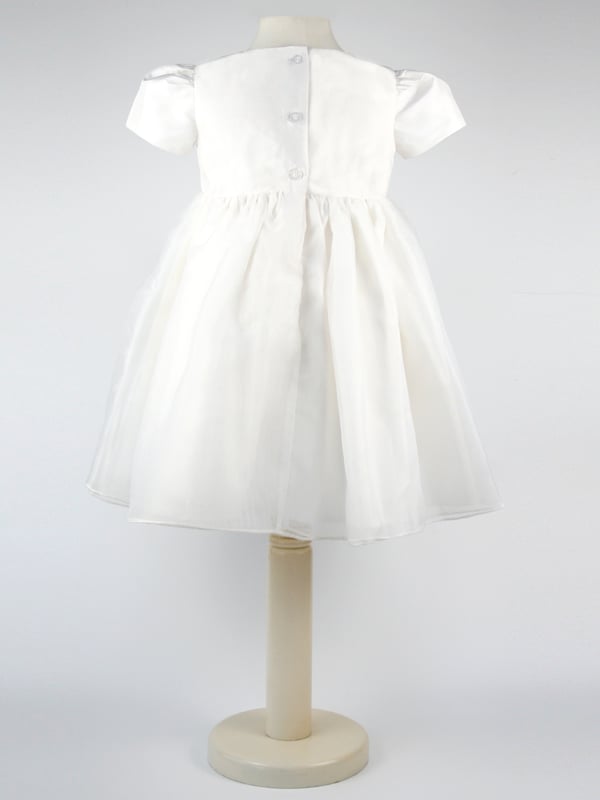 Perfect for Flower Girls, Bridesmaids or Special occasion!
'Dolly' evolved from one of our most popular dresses.

It has been beautifully re-designed to include our pin tuck detailed front, button back and gorgeous puffed sleeves to create the prettiest of dresses that is as comfortable as it is fun. Team it with a sash, ribbon or flower in any colour to match your colour scheme.

You'll find all our dresses are lined in cotton lawn for extra softness and perfect for sensitive skin.

The dress will arrive with you on a Satin padded hanger and covered in one of our Heritage garment protector bags for safe keeping.

Outer - 100% Mock Silk polyester fabric and trims

Lining - 100% cotton

Dry Clean or Hand Wash