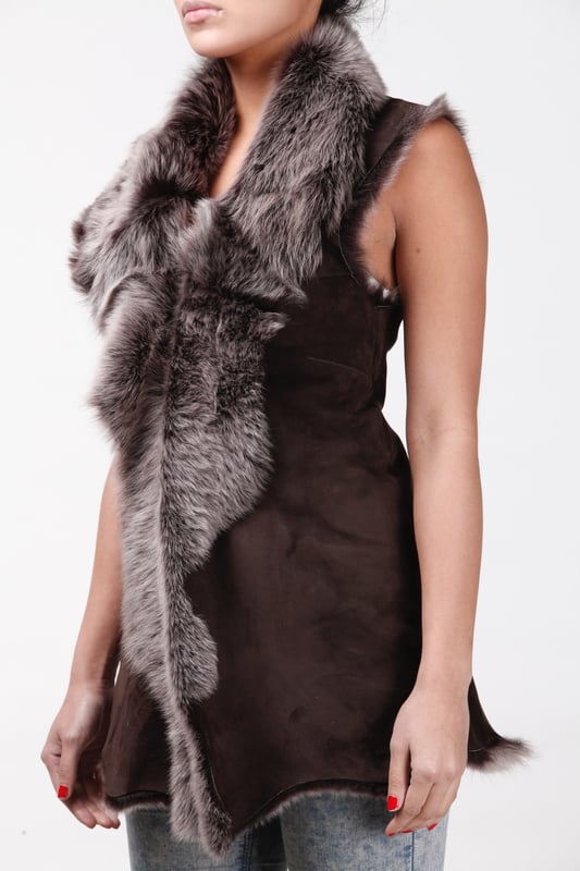 A high-quality garment that is perfect for maintaining an elegant look whilst keeping warm during the colder months. This gilet is extended in length and features our premium Spanish Toscana sheepskin, which is renowned for being amongst the warmest and most comfortable wools in the world. The soft woollen lining can either be concealed with a hook and eye fastening or exposed at the front opening in a distinctive waterfall design for an extravagant look, making it the perfect piece for adding a touch of elegance to your winter outfits. • Exclusively manufactured in the UK using double faced Toscana sheepskin • Toscana sheepskin lining is unparalleled in providing warmth and comfort • Exterior and interior painstakingly crafted for a soft silky finish • Length of 30”