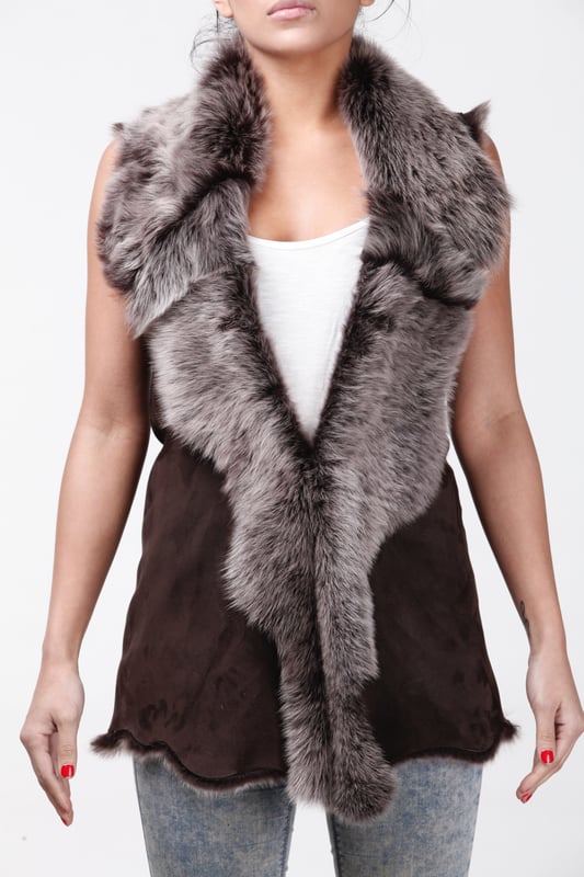 A high-quality garment that is perfect for maintaining an elegant look whilst keeping warm during the colder months. This gilet is extended in length and features our premium Spanish Toscana sheepskin, which is renowned for being amongst the warmest and most comfortable wools in the world. The soft woollen lining can either be concealed with a hook and eye fastening or exposed at the front opening in a distinctive waterfall design for an extravagant look, making it the perfect piece for adding a touch of elegance to your winter outfits. • Exclusively manufactured in the UK using double faced Toscana sheepskin • Toscana sheepskin lining is unparalleled in providing warmth and comfort • Exterior and interior painstakingly crafted for a soft silky finish • Length of 30”