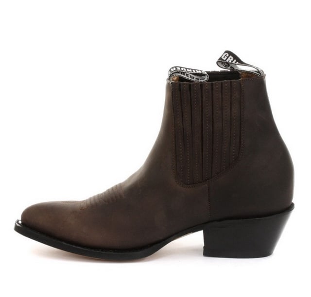 Este par de botines estilo western está fabricado íntegramente en cuero para lograr un aspecto y una sensación sofisticados. La parte superior es resistente a la abrasión para una mayor durabilidad y, para agregarle carácter, presentamos detalles de costuras intrincadas en la parte delantera. La parte delantera del zapato se completa con una puntera puntiaguda y los costados cuentan con una línea superior elástica, así como dos presillas con la marca para ponérselas fácilmente. La suela de este zapato tiene la marca del bulldog de Grinders y se ha unido con calor a una vira para brindarle a este zapato mayor resistencia y durabilidad. • Costura Goodyear • Parte superior de cuero • Forro de cuero suave • Tacones de cuero apilados • Suelas de cuero • Fabricado en México